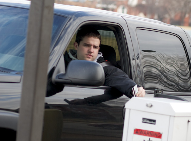 Sophomore Stephen Koniak uses his SLU ID to enter the Loyola lot on Feb. 23. Around 8,000 SLU students and faculty utilize spaces in parking lots and garages maintained by Parking & Card Services. SLU’s current parking permit system has been in place since 2000.Noah Berman / Photo Editor