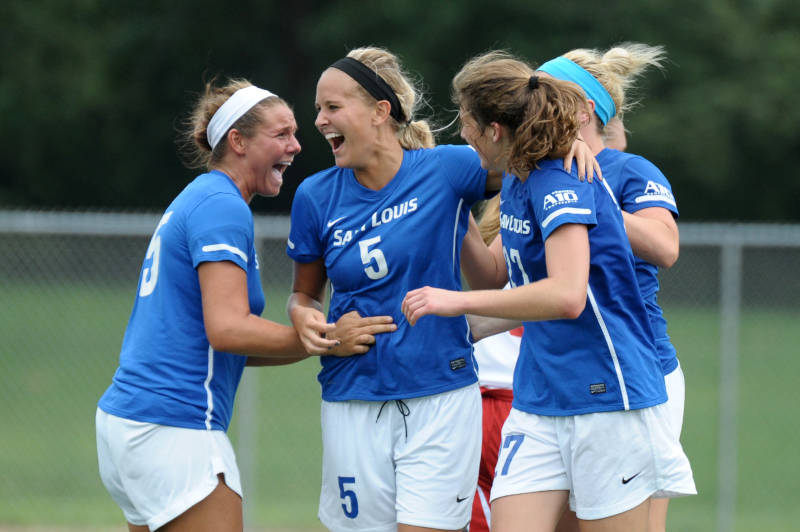 The women's soccer team celebrates after Alli Reimer scored a goal in the 89th minute to lead the Billikens to victory