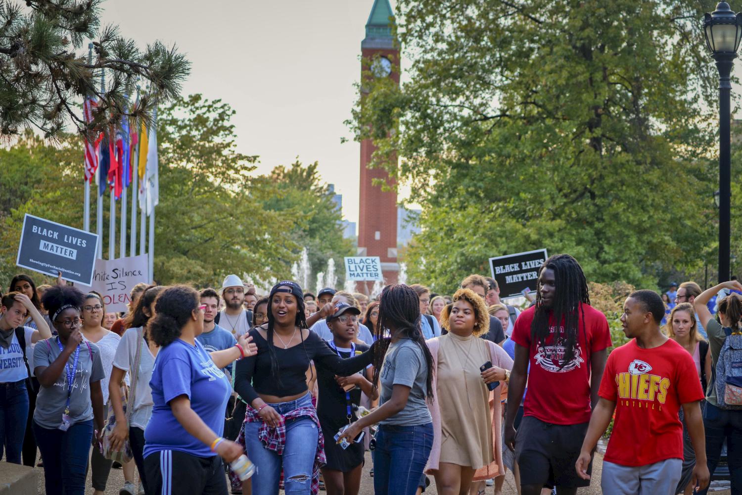 SLU student protesters march from the clock tower past the CGC towards the Busch Student Center.