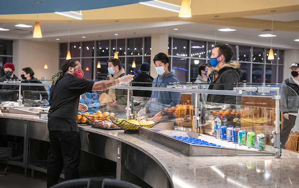 DineSLU employees serve food to SLU students in Grand Dining Hall