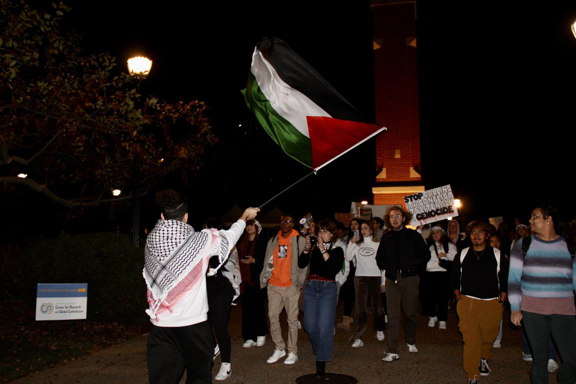 Sophomore Nader Badwan waves a Palestinian flag as he leads a protest on Nov. 2 
(Abby Campbell / The University News)
