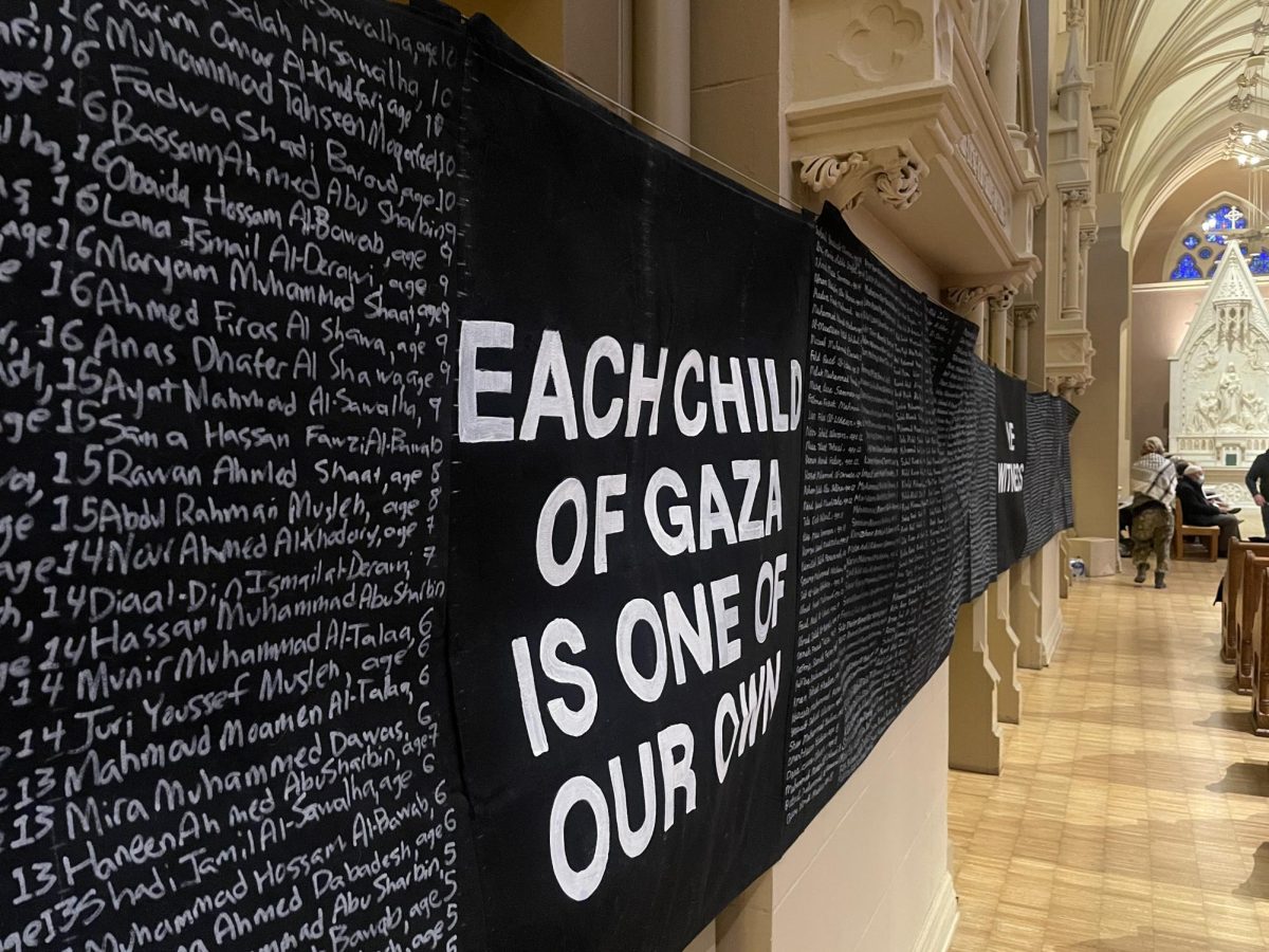 On a wall inside College Church, a long black banner hangs bearing the names of children killed in the Gaza Strip.