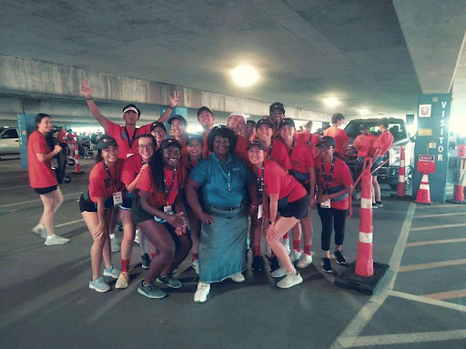 Janette Holemon, parking attendant at the Laclede parking garage at Saint Louis University, poses for a photo with a group of Oriflamme students during move-in. (Jennifer Robb/Parking and Card Services)