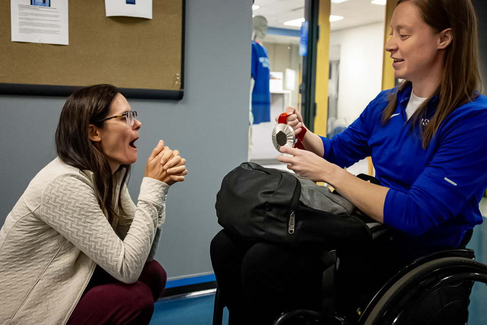 Sarah Adam showing her co-workers the silver medal she won on Sept. 10, 2024. 