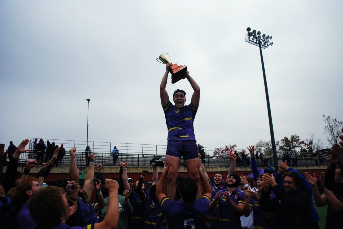 Saint Louis University Rugby holding player, Ean Fagan, in the air after their Conference winning match against Missouri S&T.