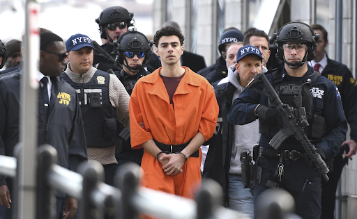 Luigi Mangione escorted by NYPD police Dec. 19, 2024, to face four counts of federal charges. (Pamela Smith / AP) 