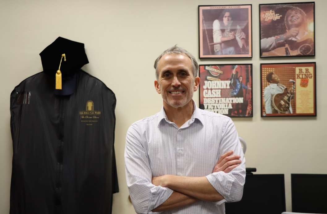 Rob Boyle, associate professor of management at Saint Louis University, stands in his Chaifetz School of Business office on Feb. 10, surrounded by symbols of his dual passions: academia and music. Through his course, “Rhythms of Innovation,” he explores the intersection of creativity, technology and business. (Photo by Jude Thomas / The University News)