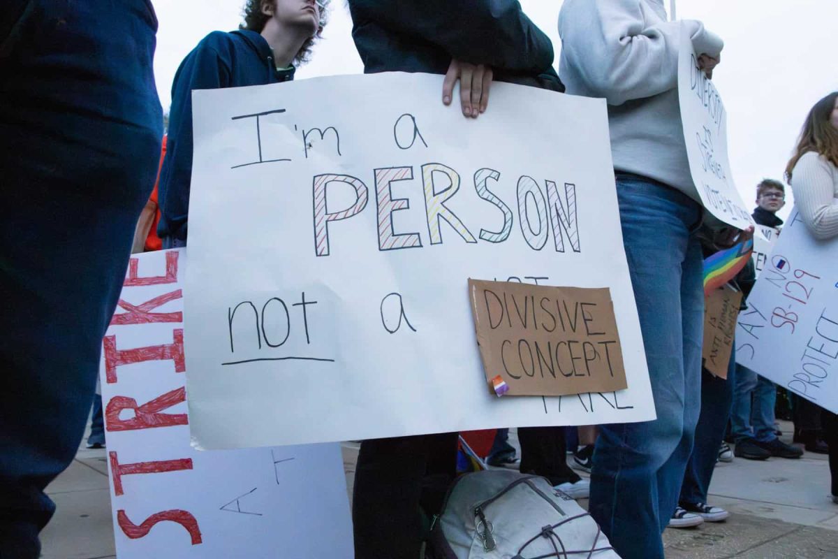 A sign at a protest, saying "I'm a person not a divisive concept." Photo courtesy of The Crimson White at the University of Alabama.