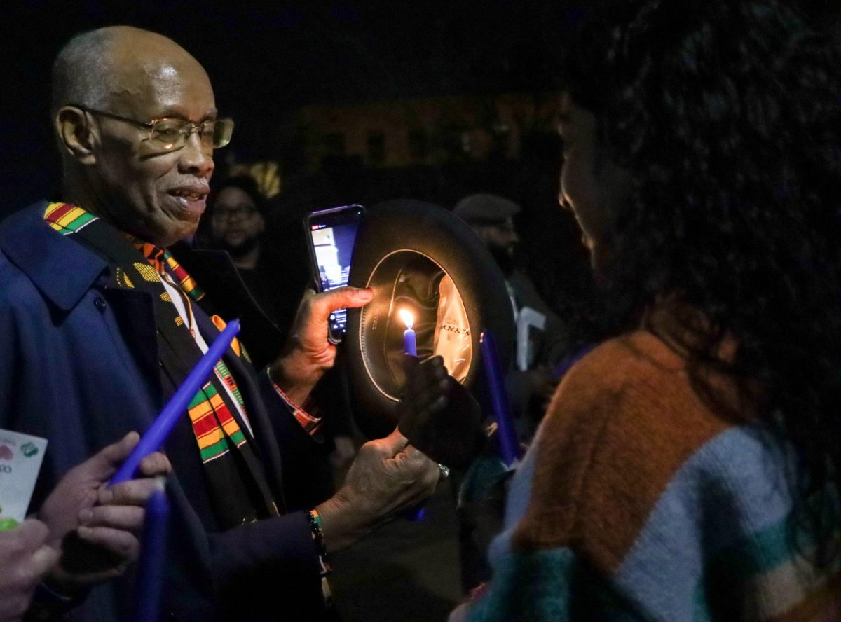 Pastor Greg Holley shields his candle's flame from the wind at the "Lights of Remembrance" vigil near Saint Louis University's Clock Tower on Feb. 27, 2025. Holley is a descendant of people enslaved by Jesuits and the university and spoke at the vigil about the importance of honoring his ancestors. 