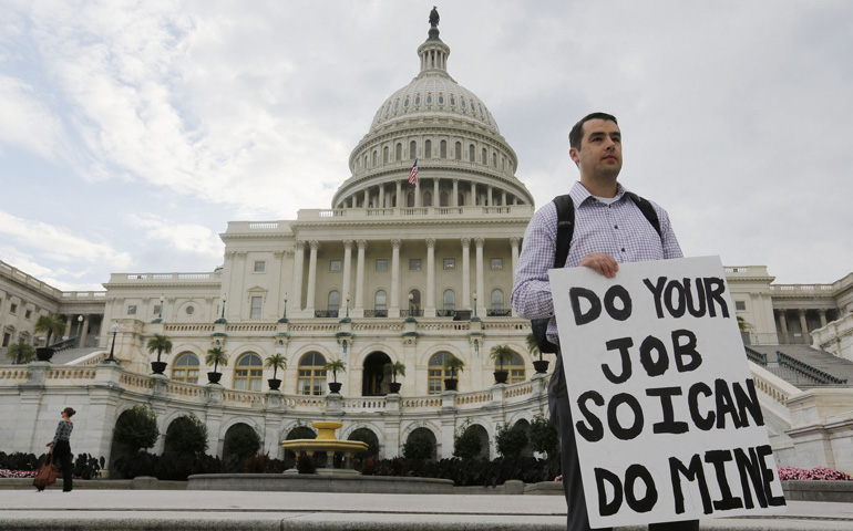 A furloughed federal employee protests, holding a sign on the steps of the U.S. Capitol after the government shut down (CNS/Reuters).