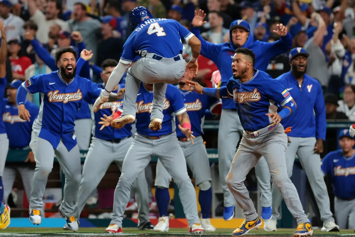Pinch-runner Javier Sanoja, No. 4, celebrates with his Venezuelan teammates after scoring the go-ahead run in the top of the ninth inning versus Team USA in the World Baseball Classic in Miami, Florida on Tuesday, March 17, 2026. 